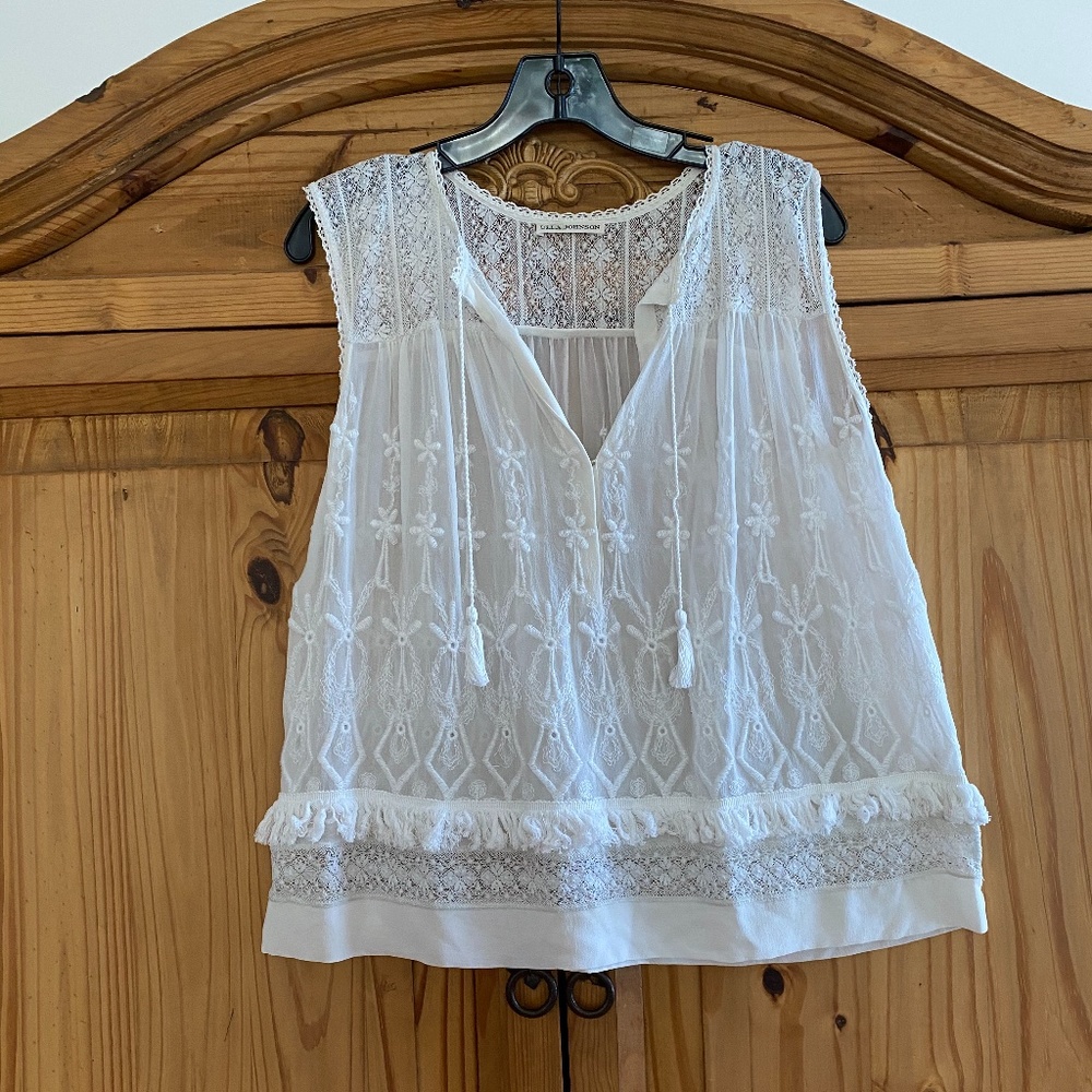 Sheer white embroidered top with fringe.